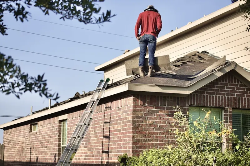 Professional roofer working on a residential roof in Clay Arsenal